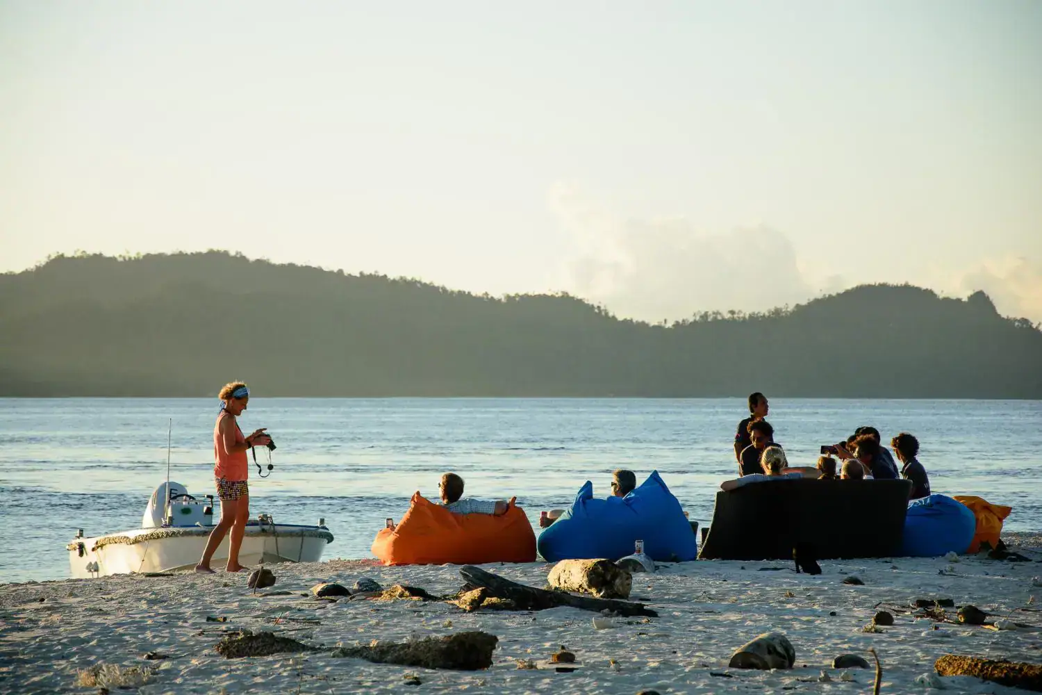 beach set up, evening beach view, hills in the background, ottomans on the beach, relaxing 