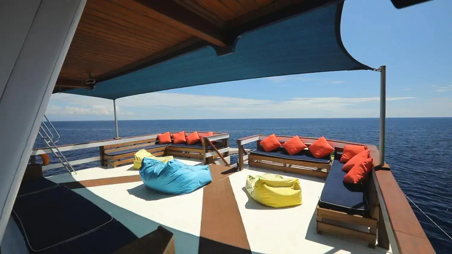 upper deck b, relaxing spot, wide view, clear sky, red pillows, yellow and blue ottomans